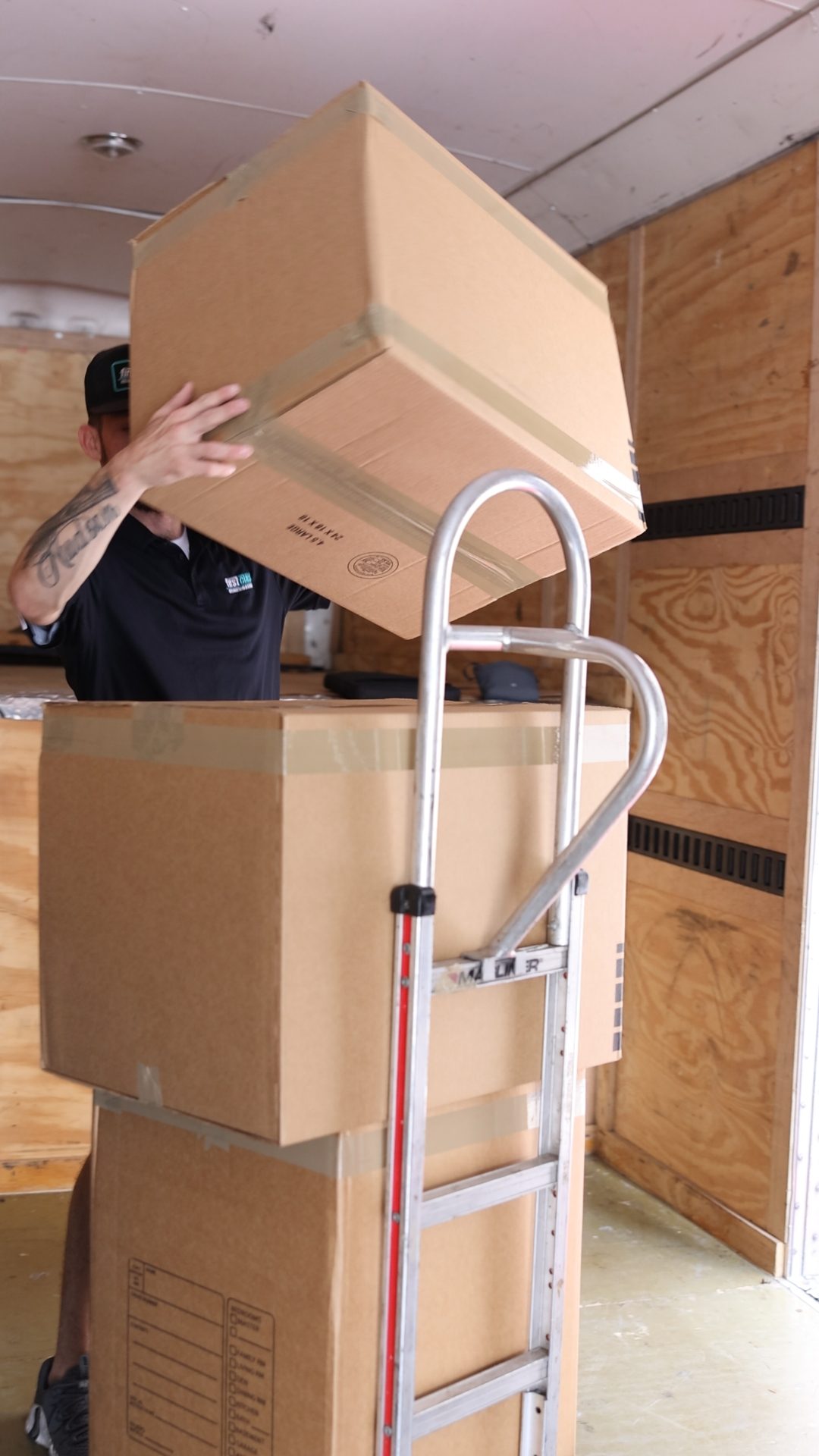 Mover stacking boxes on a dolly during a commercial office move in Dallas Fort Worth